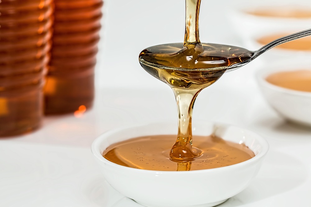 Sirup auf einem Löffel, der über eine Schale gehalten wird