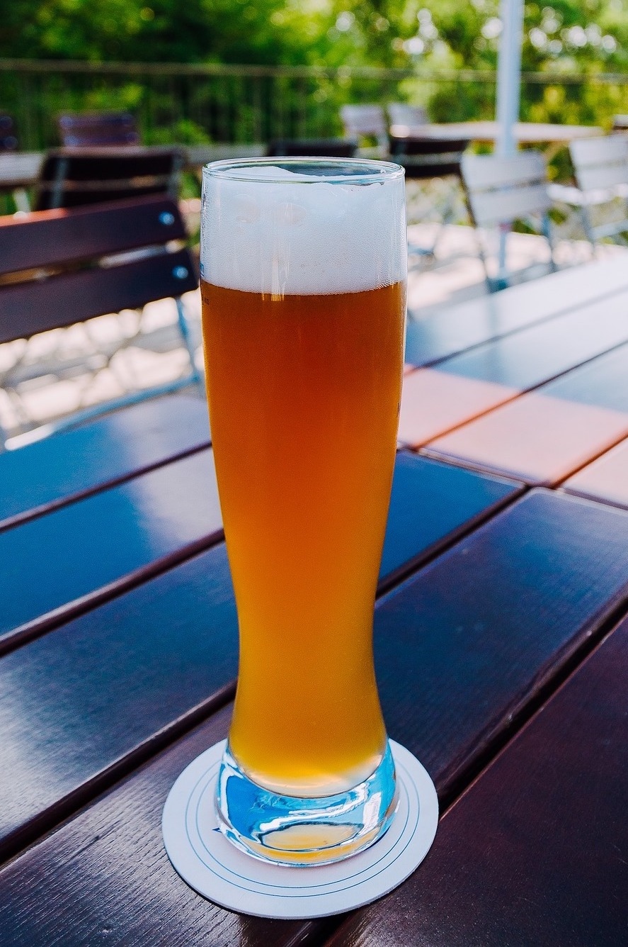 Ein Glas Bier auf einem Tisch im Freien.