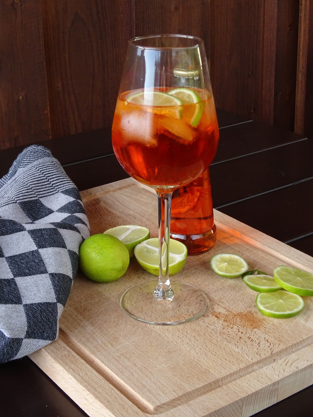 Glas mit Ploperol gefüllt, auf Schneidebrett stehend mit Limettenscheiben