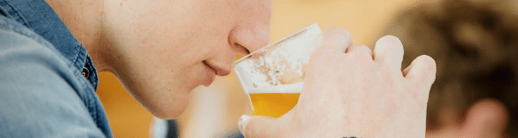 Mann riecht an Bier
