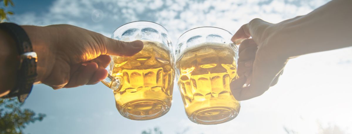 Zwei Personen stoßen mit Biergläsern an