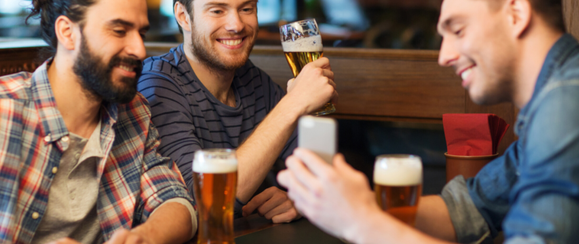Männer trinken Bier und schauen sich Bierentdecker.com an